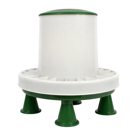 A white and green plastic cylindrical feeder or dispenser with a wide circular base, four short legs, and a ring of small openings around the middle, shown on a plain white background.